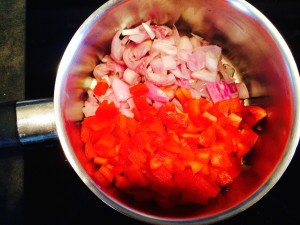 oignons poivrons rouges coupés dans une casserole